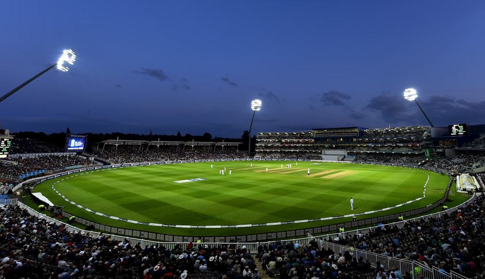 Floodlit cricket stadium at dusk